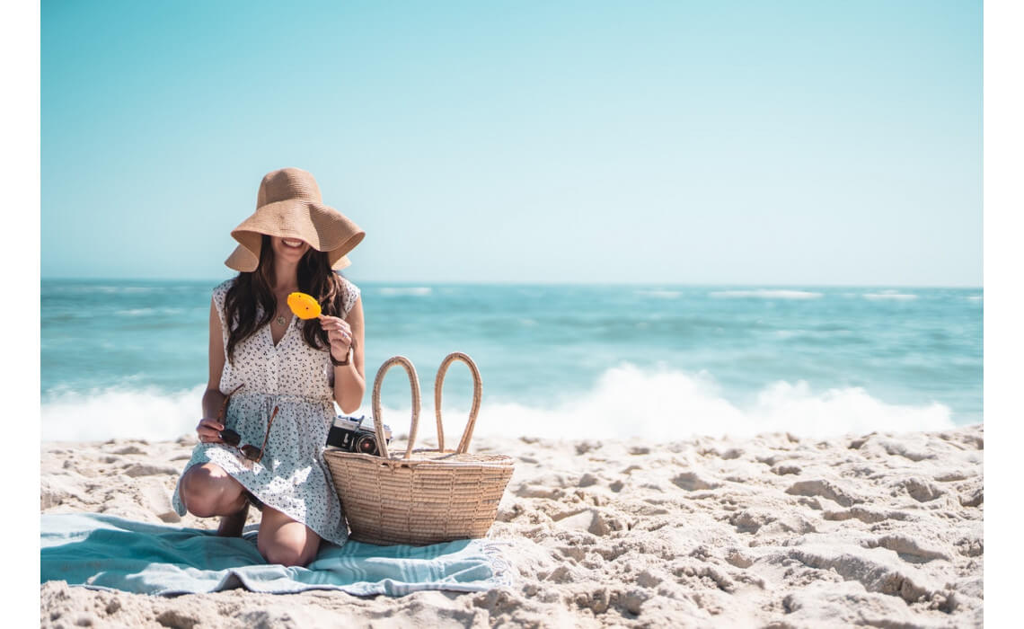 Femme avec chapeau sur la plage en été.