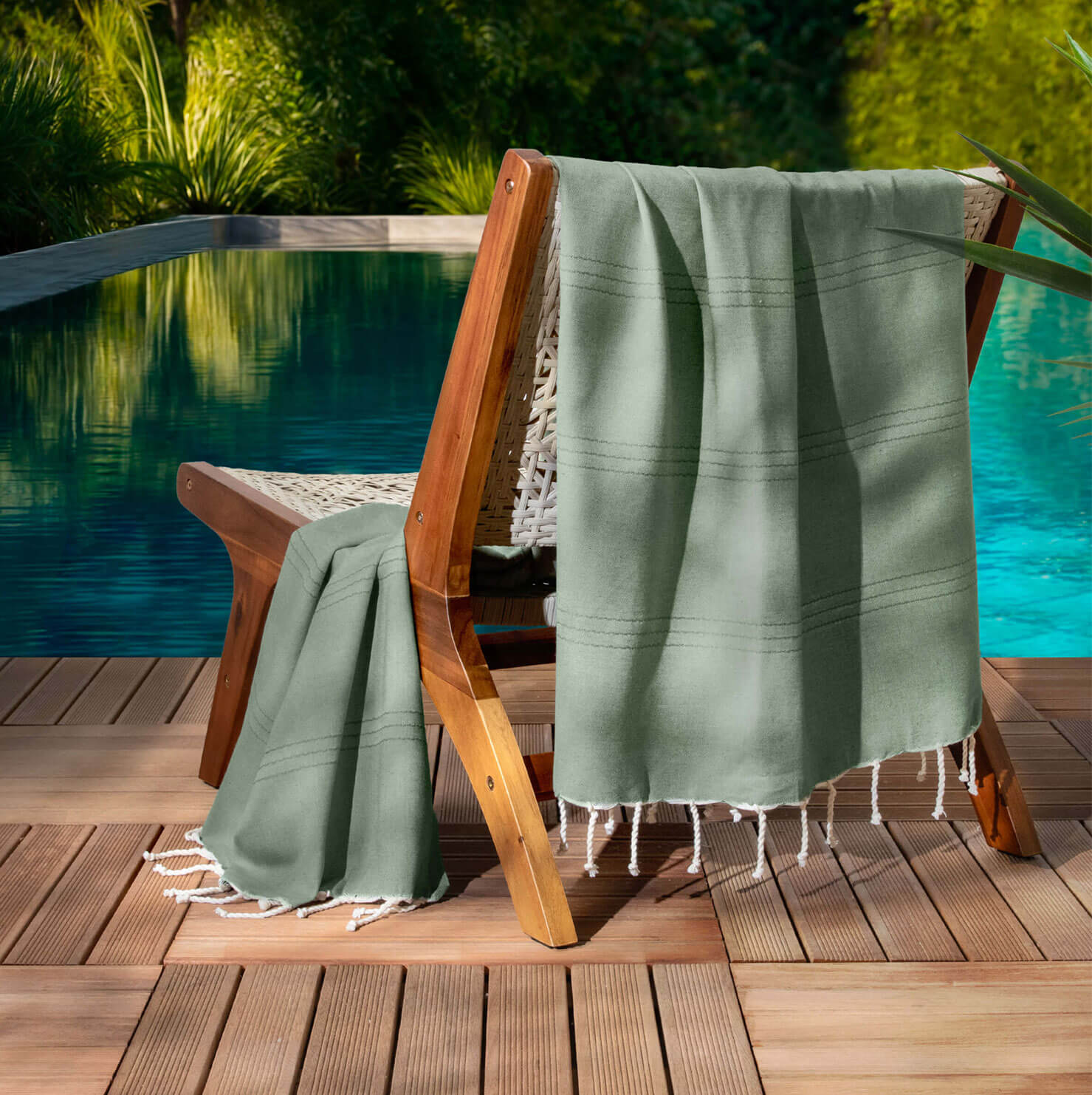 Chaise bois avec serviette au bord de la piscine.