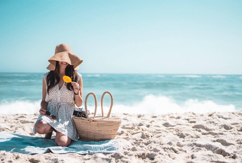femme utilise une fouta à la plage comme serviette

