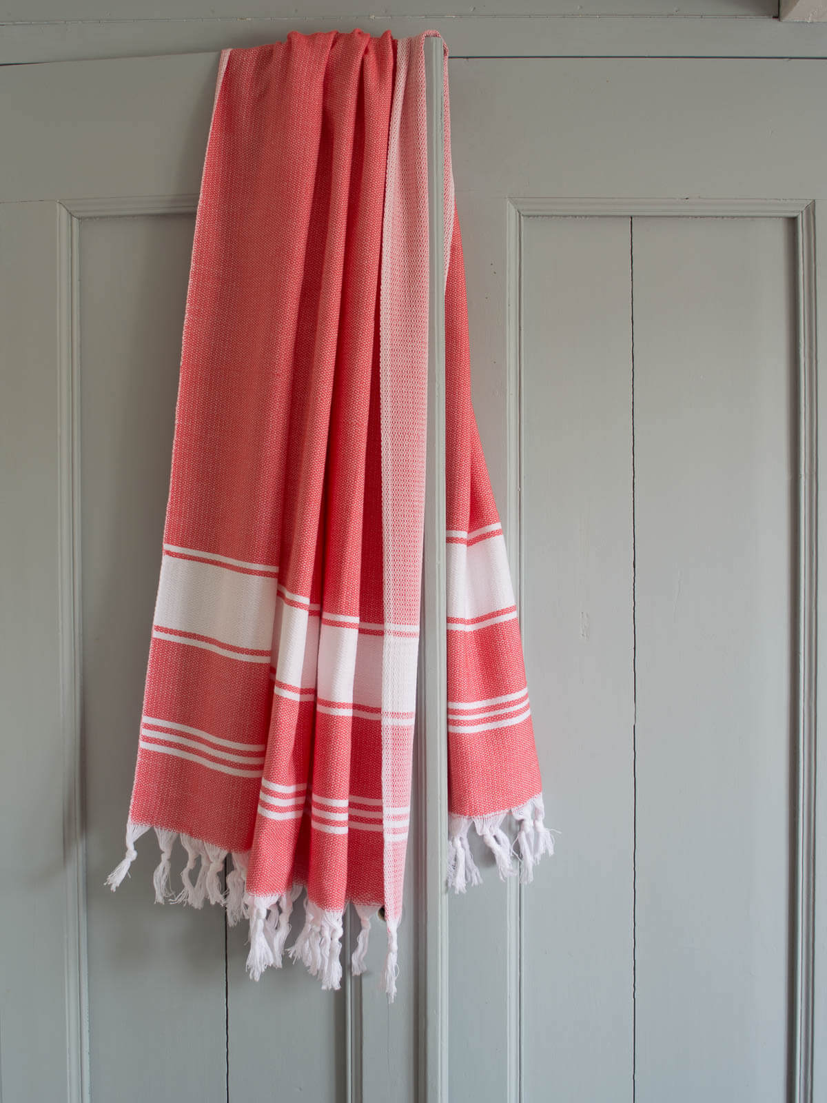 Serviette rose et blanche suspendue à une porte