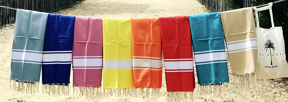 fouta industrielle france Foutas colorées suspendues sur une plage ensoleillée.