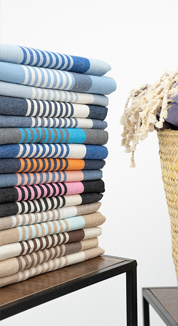 Pile de serviettes colorées sur étagère.